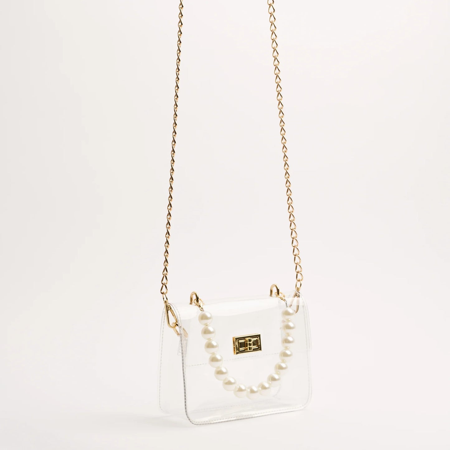 audrey stadium bag with pear and gold accents handing from the gold chain crossbody strap