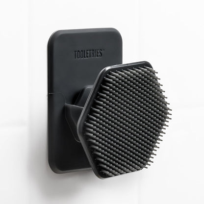 face scrubber set in holder attached to white wall.