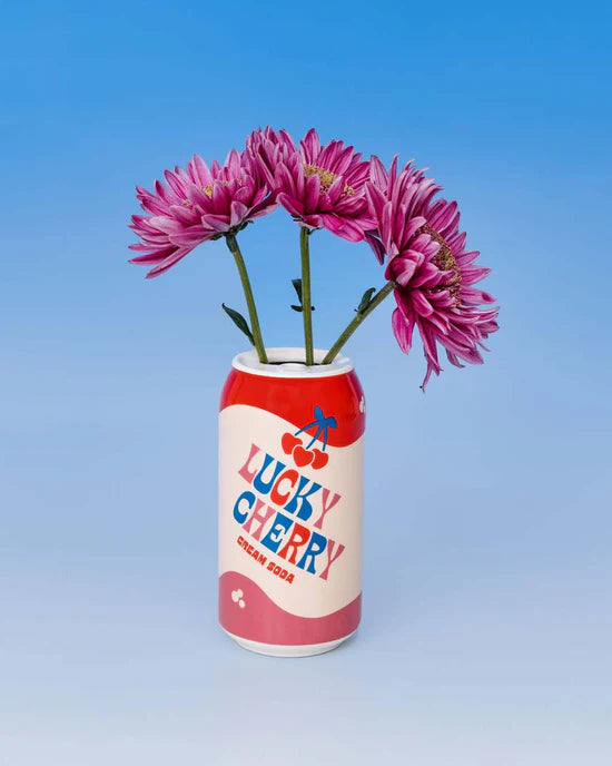 other side of lucky cherry vase with text " lucky cherry cream soda" and the image of cherries on it and filled with pink flowers.