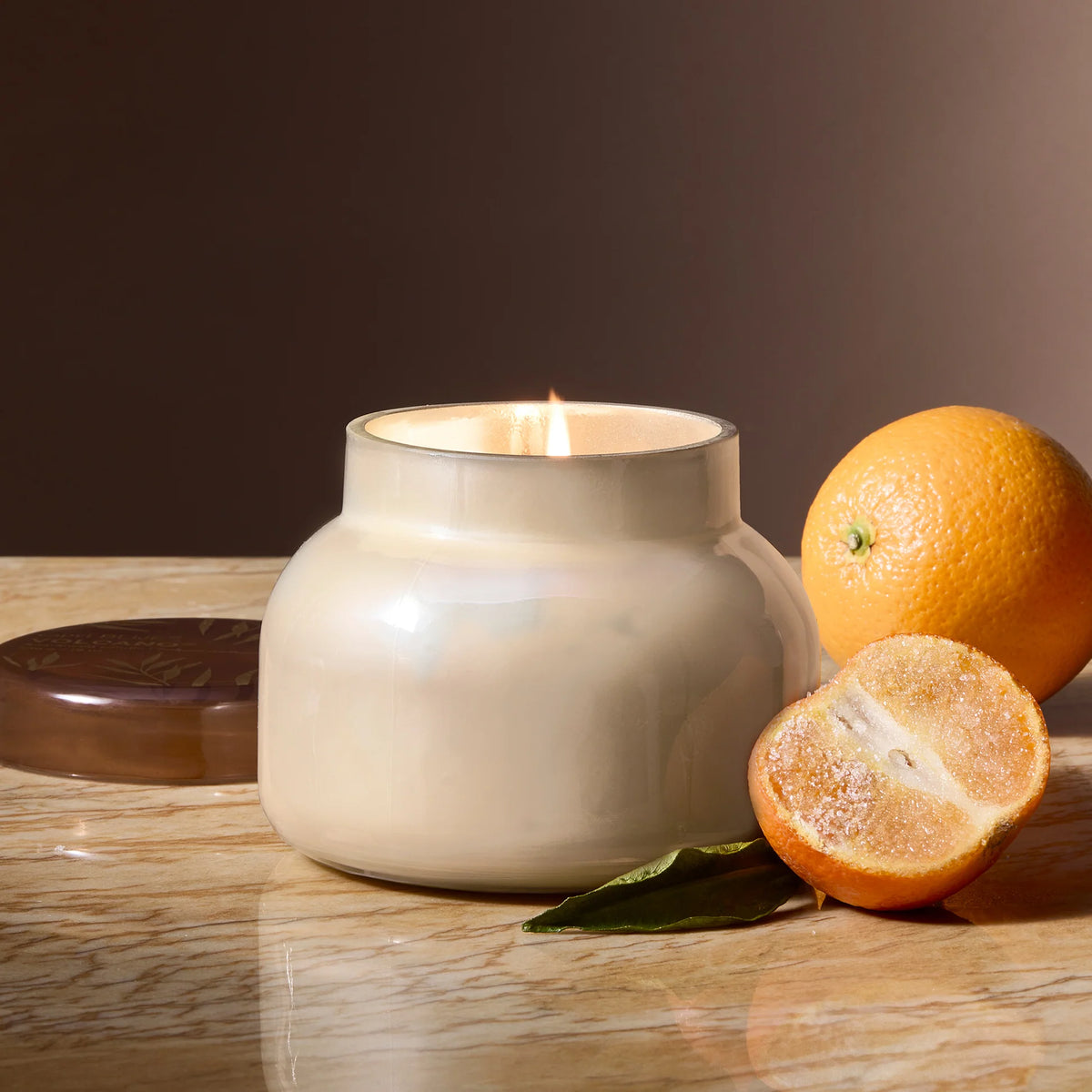 lit Autumn Glow candle surrounded by sugared citrus