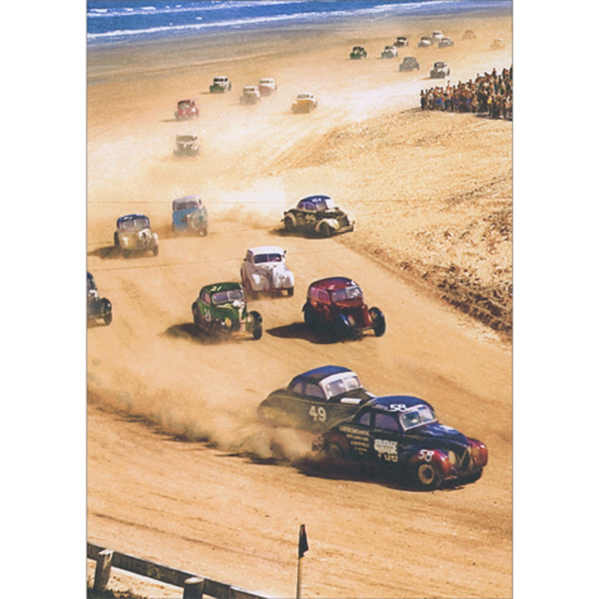 front of card is a photo of old-fashioned race cars racing along a sandy beach