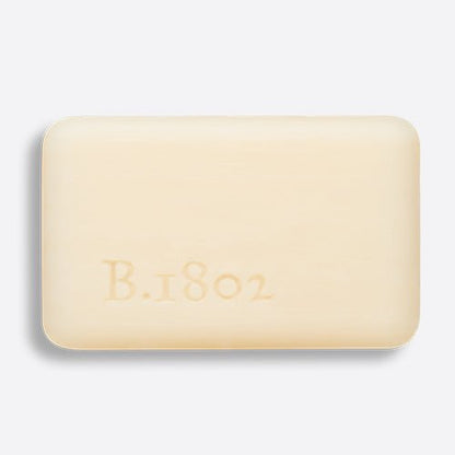 unwrapped bar of pure goat milk bar soap with "B 1802" stamped onto it.