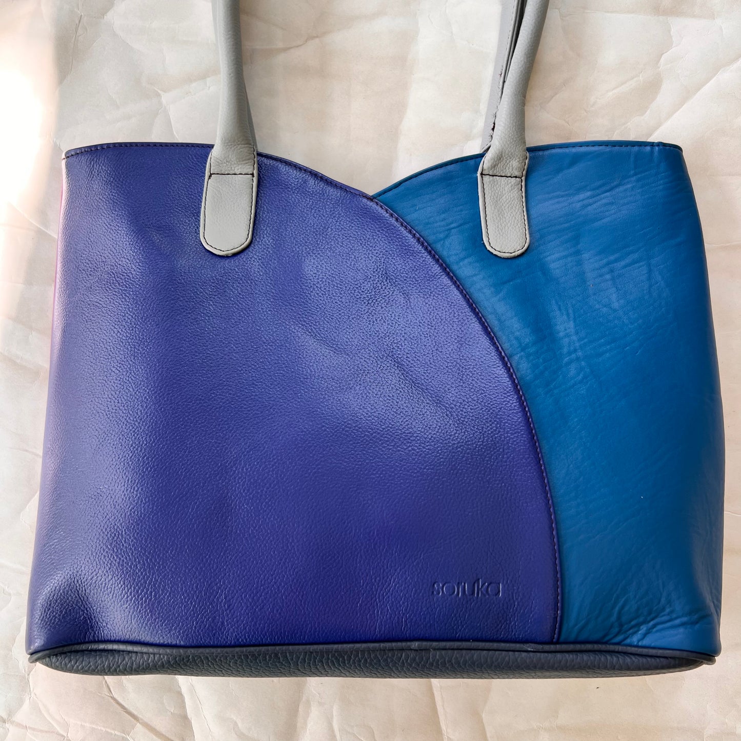other side of valeria tote that is half bright blue and half royal blue.