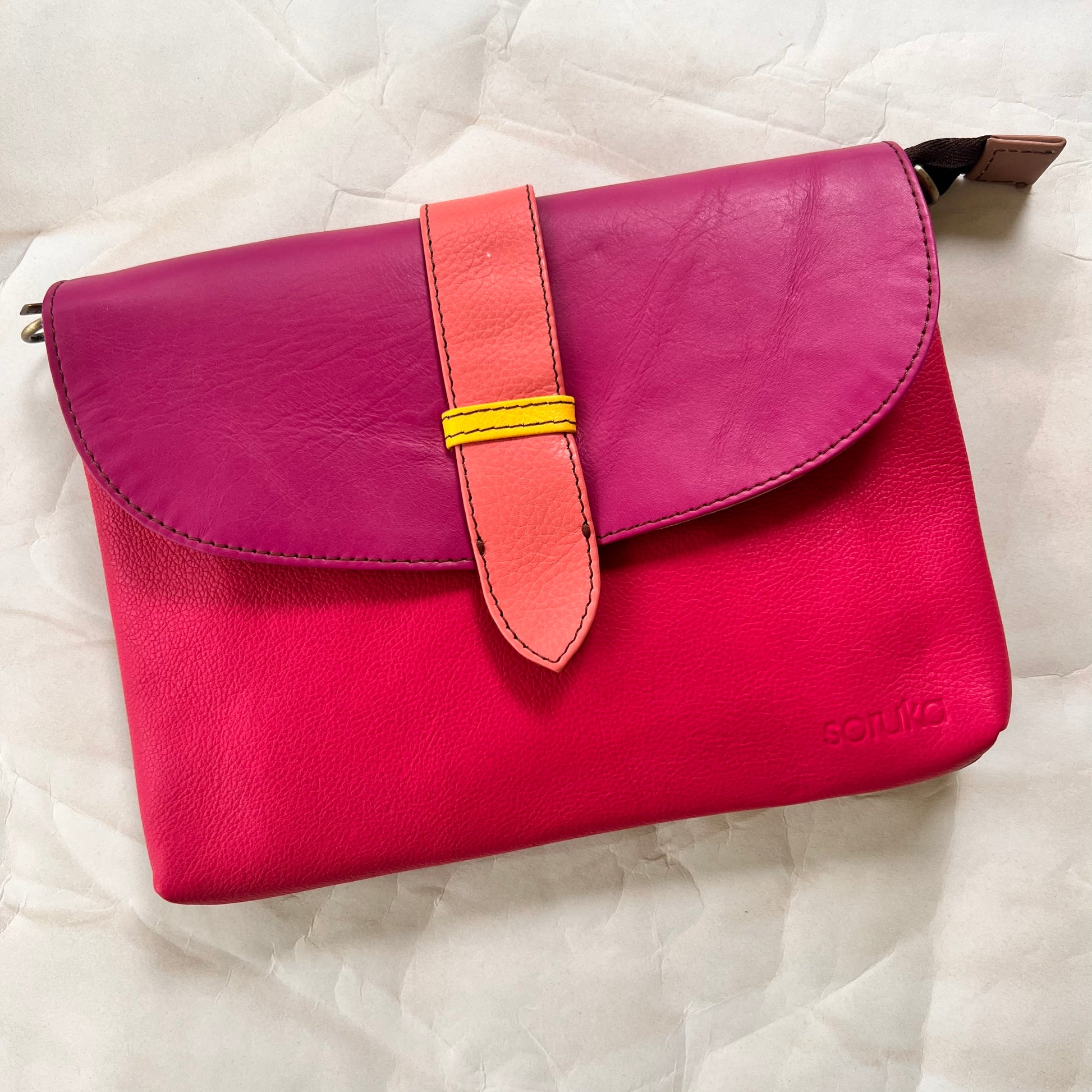bright pink saddle bag with pink flap and peach tab.