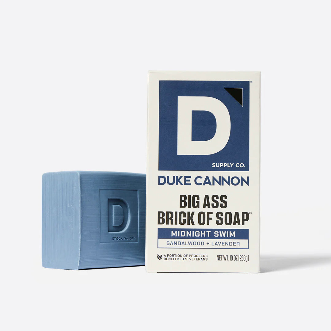 Blue bar of soap next to its packaging on a white background