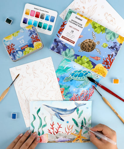 Coloring book with ocean-themed illustrations, watercolor set, and painting tools on a blue background