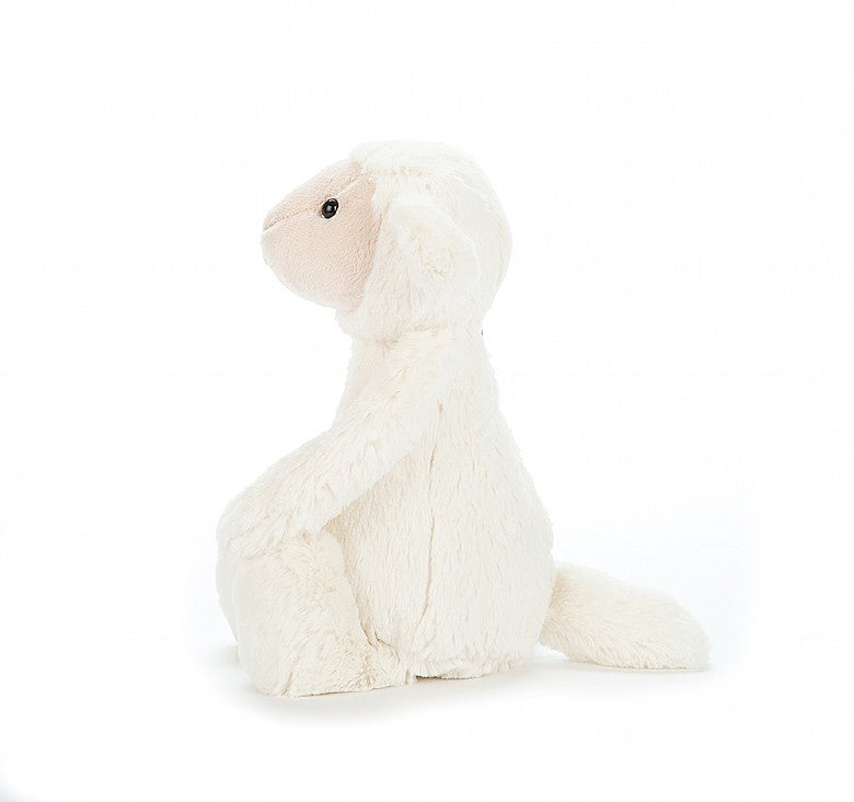 side view of bashful lamb plush toy on a white background