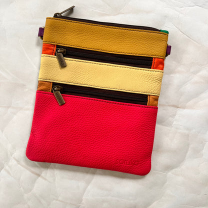 flat rectangular maya bag with top zipper and 2 zipper pockets color blocked in pink and yellows.