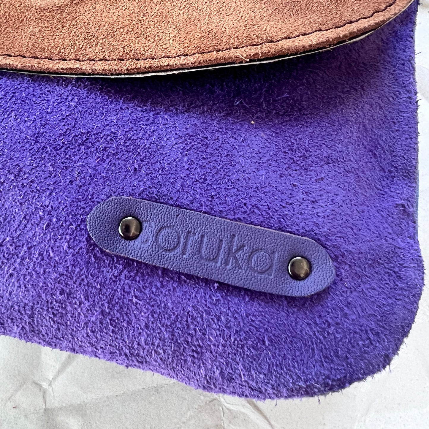close-up of corner of purse showing "soruka" logo.