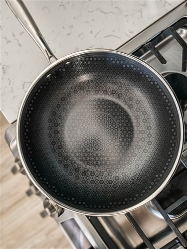 top view of 11 inch black ceramic frypan placed on a stovetop.
