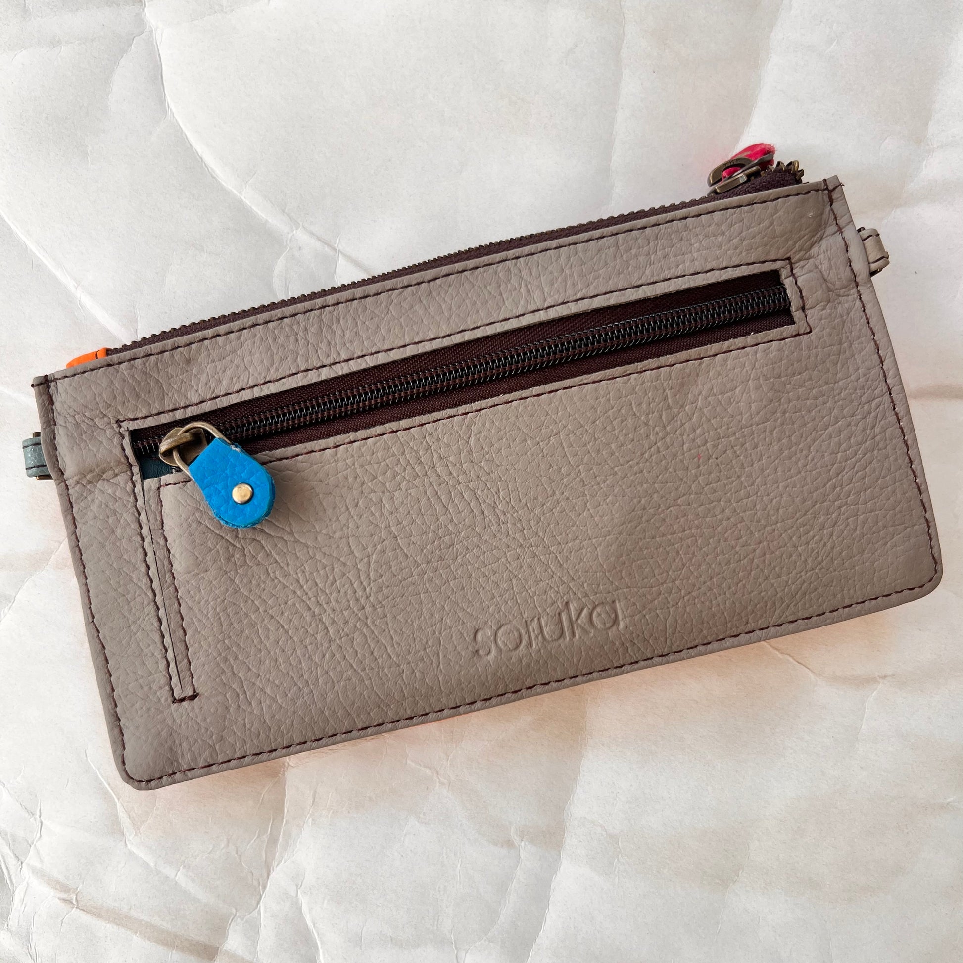 solid grey back of kimber wallet with zipper pocket.