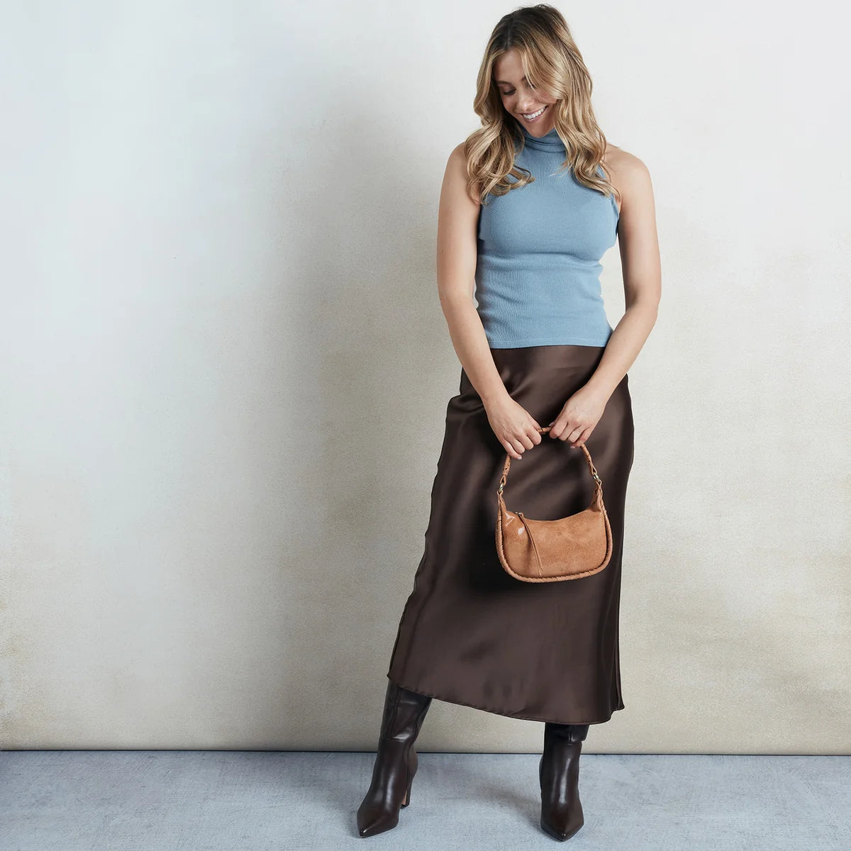a person holding the mia crossbody small in color whiskey