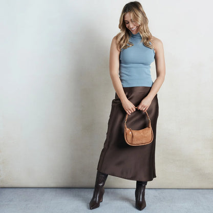 a person holding the mia crossbody small in color whiskey