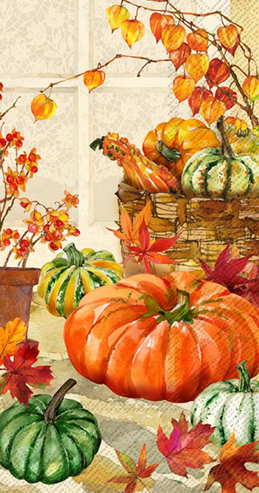 paper napkin printed with artwork of pumpkin in a nd around a basket with fall foliage around it.