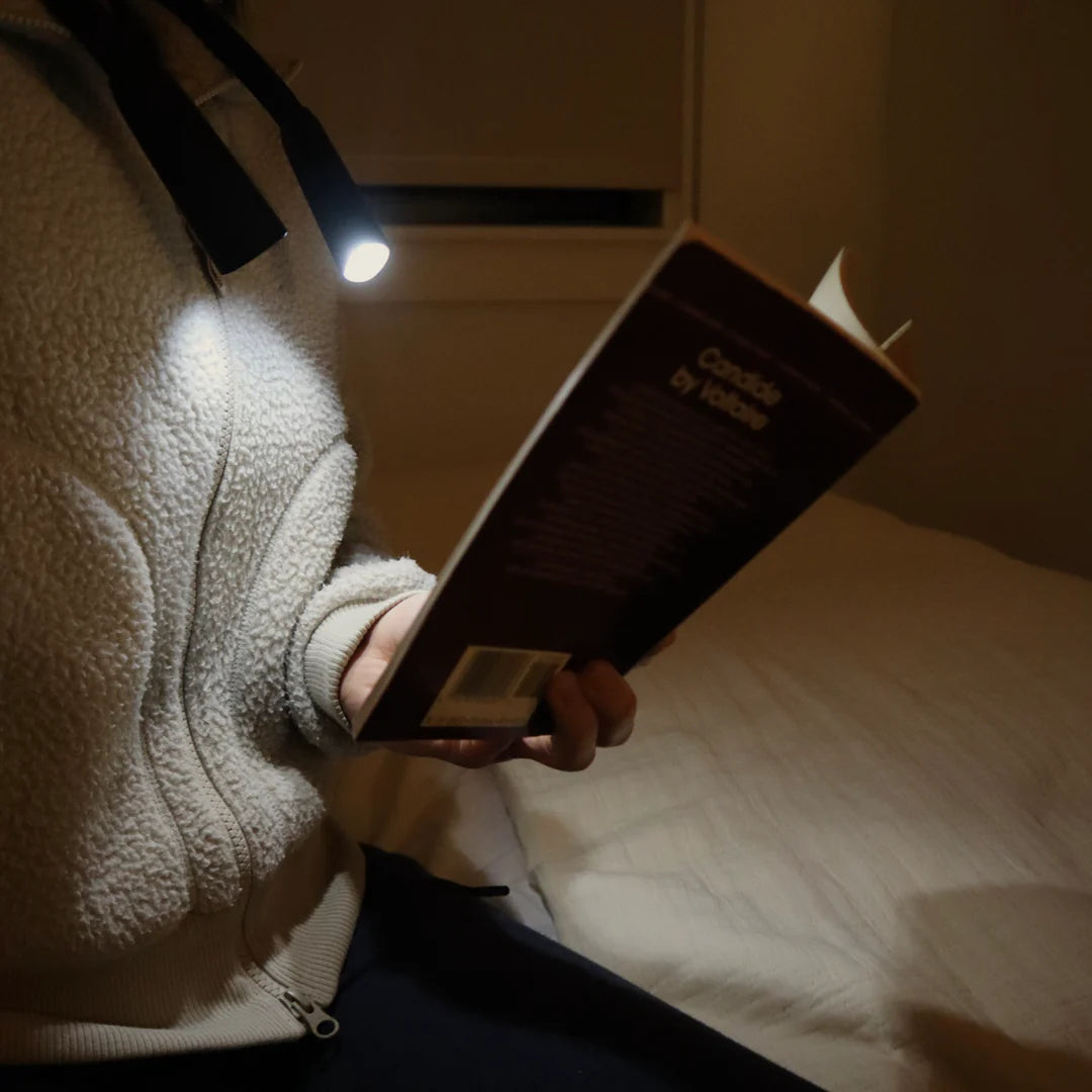 side view of person reading using the flexible neck lamp.