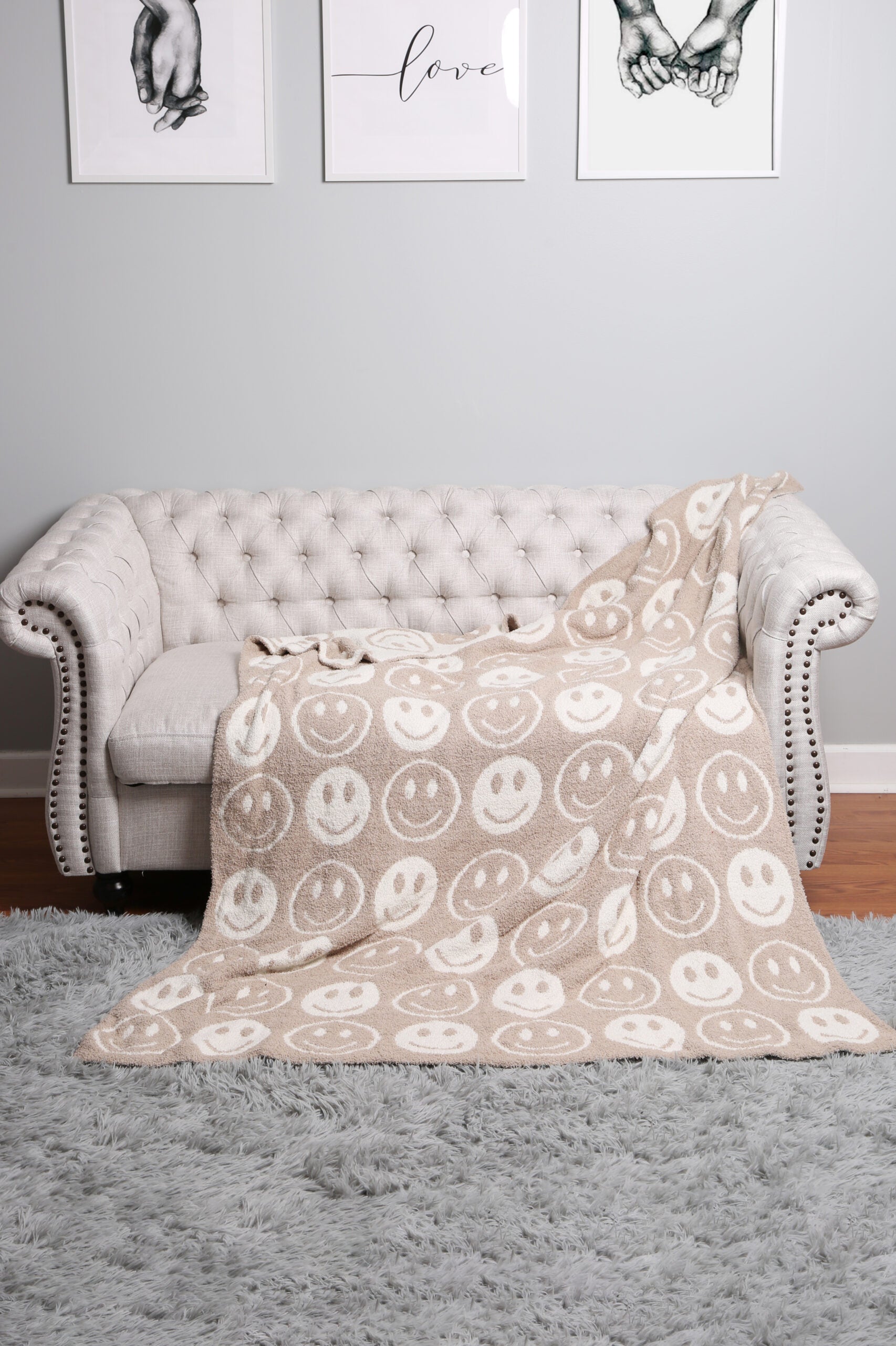 beige throw blanket draped over a grey couch.