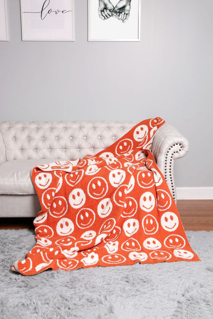 orange throw blanket draped over a grey couch.