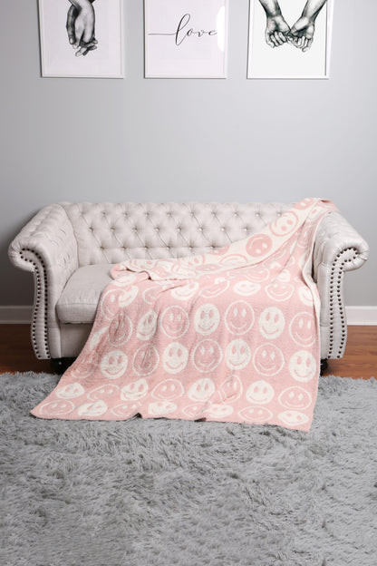 pink throw blanket draped over a grey couch.