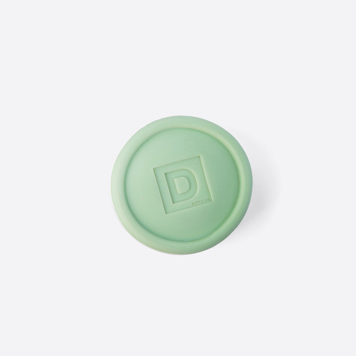 high country scent soap puck in a pale green color on a white background