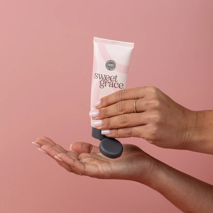 tube of sweet grace hand lotion being squeezed into someone's hand