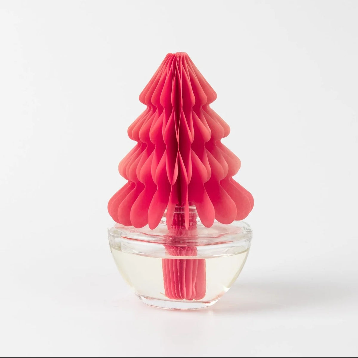 bright pink honeycomb-shaped tree sitting on a clear container filled with fragrance oil shown on a white background