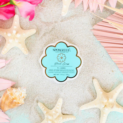 Spongelle product on sand with starfish and flowers