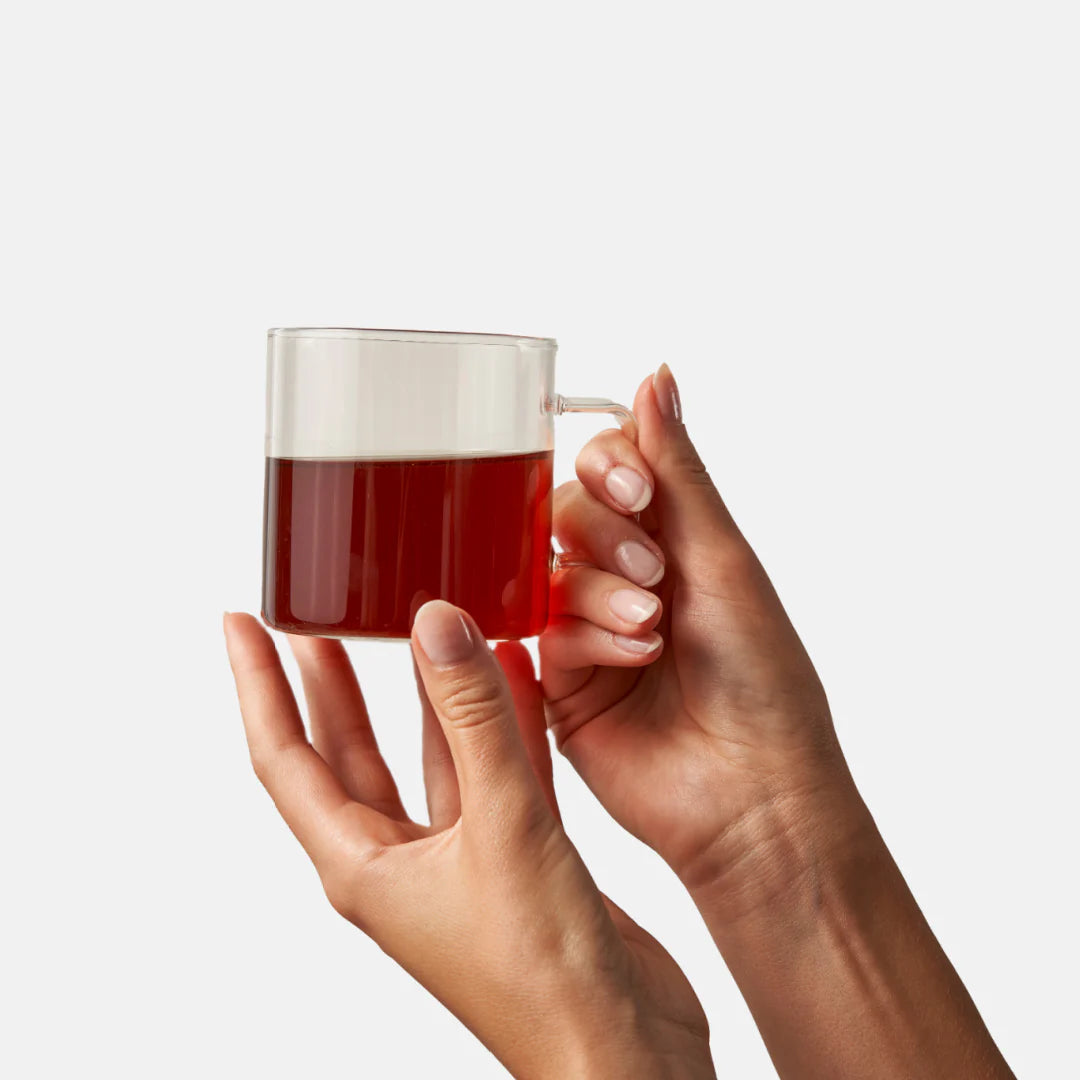 hand holding glass mug filled with Chai Tea 