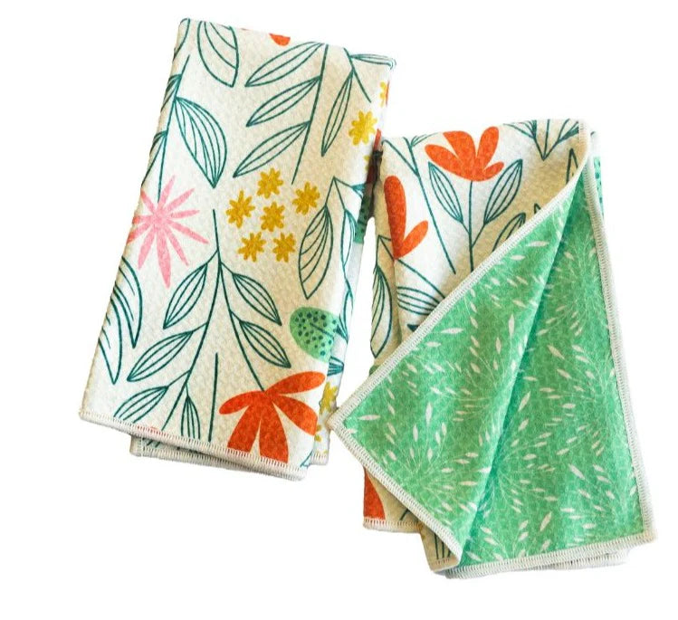 2 white biggie towels printed with a floral design, one towel is folded showing the reverse green side.