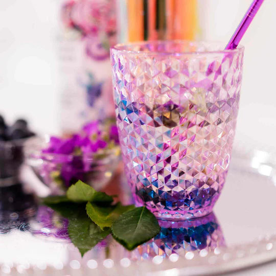 close-up of faceted drinking glass set on a tray with sprigs of lavender and flowers.