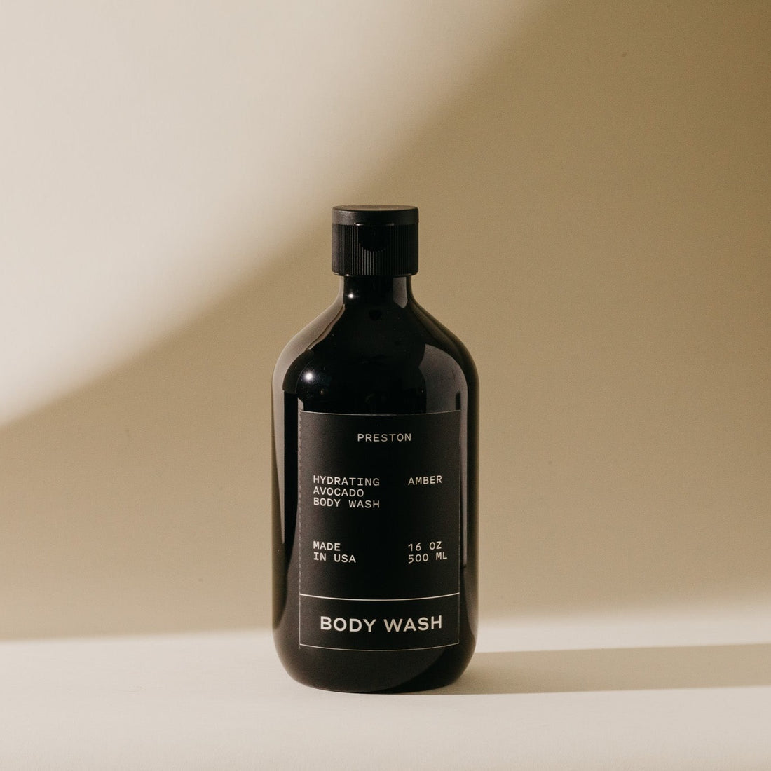 front view of amber body wash in a black bottle