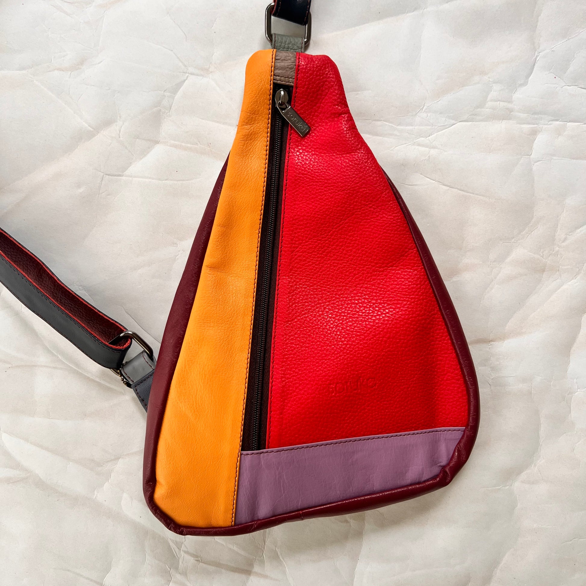 front view of cranberry roxi sling bag.