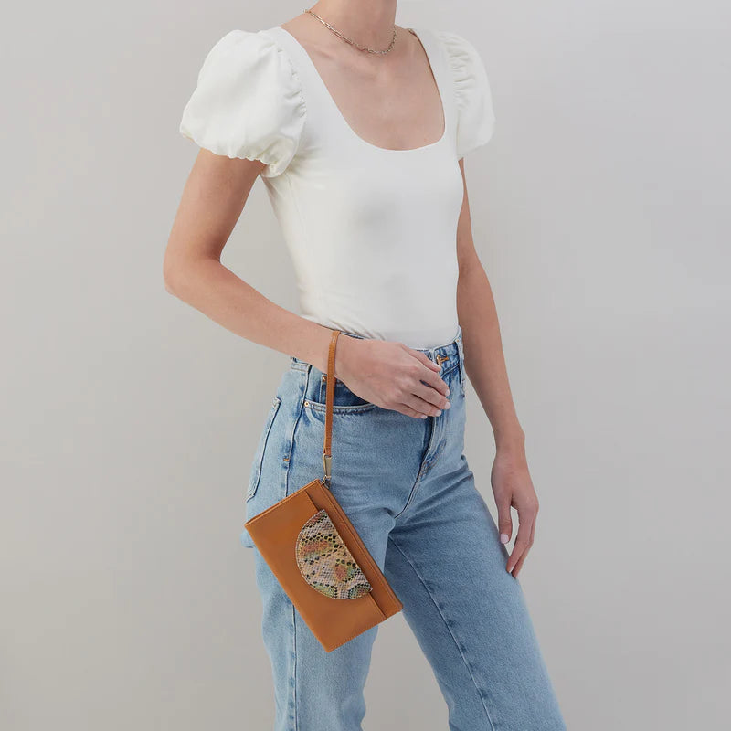 person wearing jeans and a white top with natural zenith wristlet  hanging from her wrist.