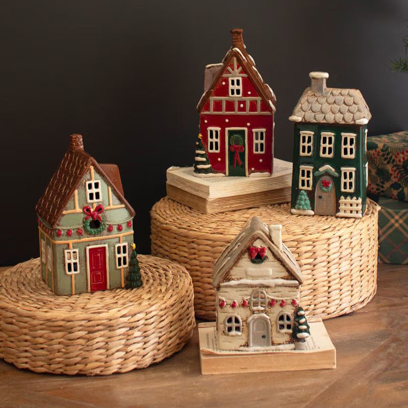 Set of decorative miniature houses on woven stands against a dark background