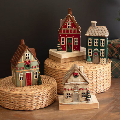 Set of decorative miniature houses on woven stands against a dark background