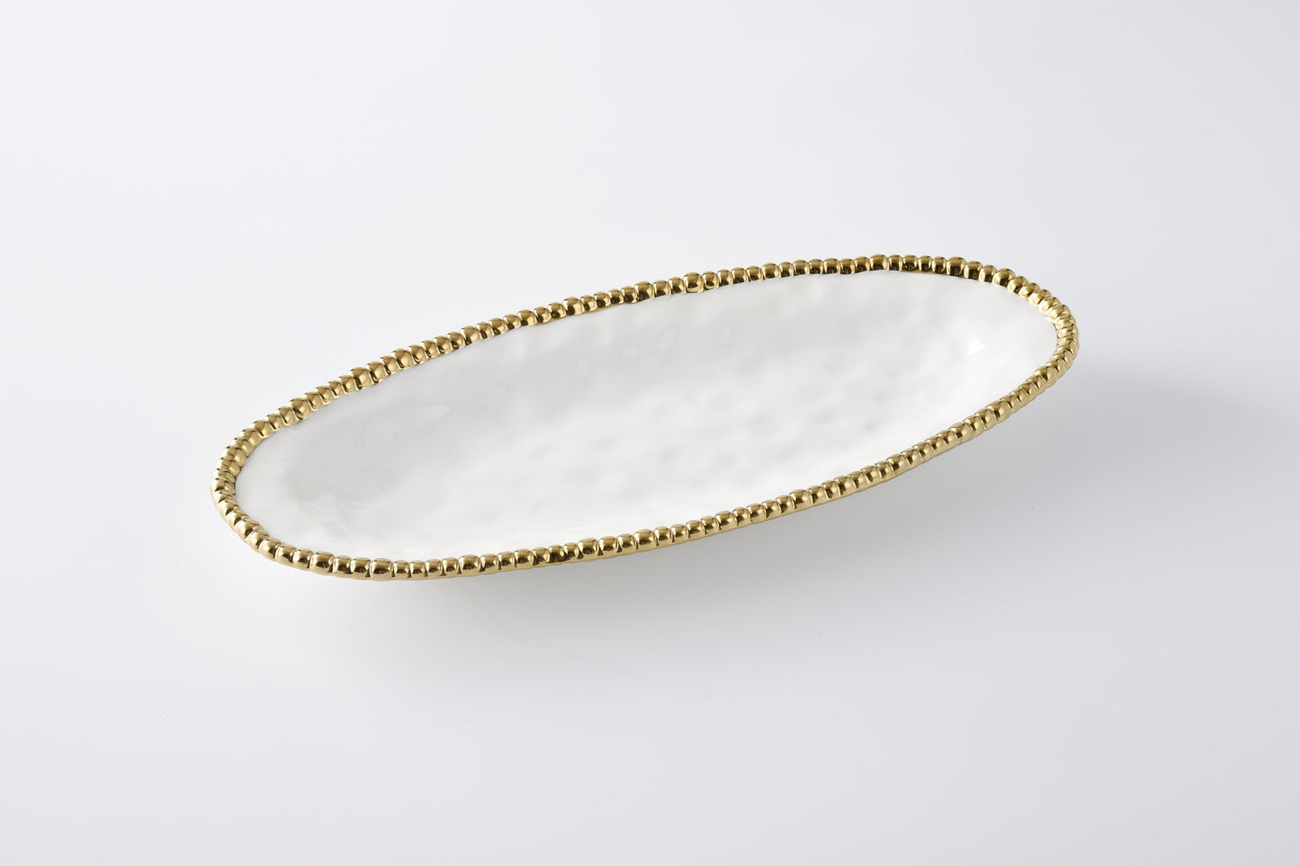 white oval serving platter with gold beaded rim shown on a white background
