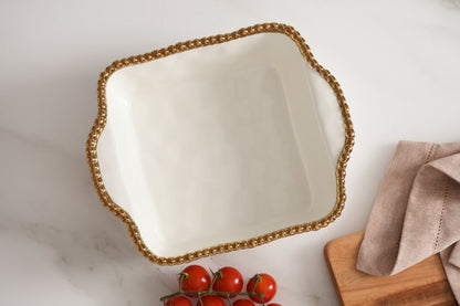 top view of white baking dish with gold rim set on a marble surface