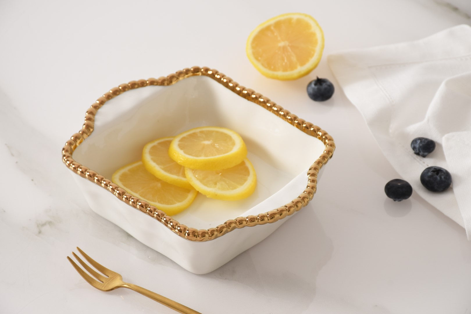 white and gold Square Mini Baker with fruit in it
