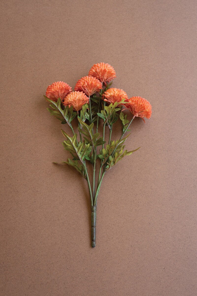 Bouquet of orange flowers with green leaves on a brown background