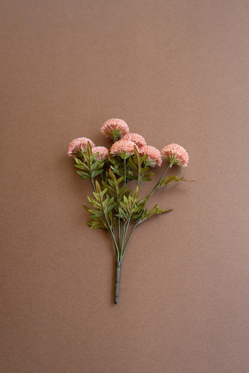 Artificial flower branch with pink flowers on a brown background