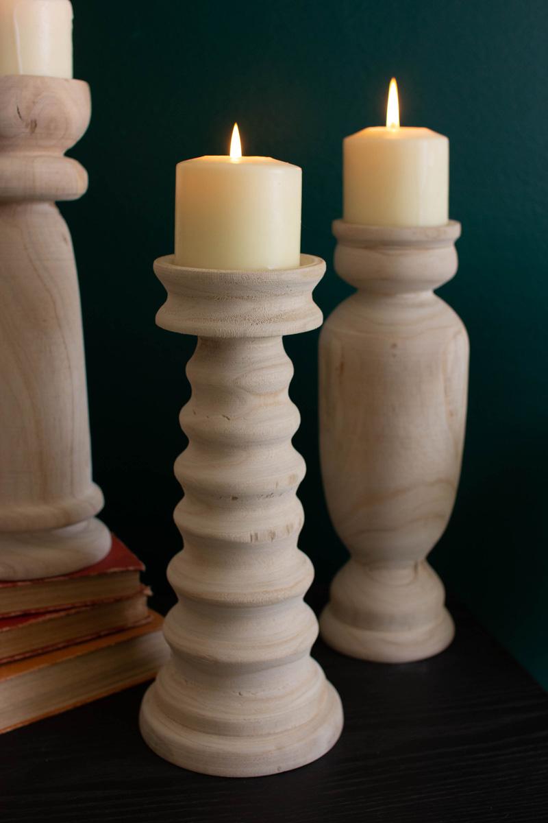 close-up of wooden candle holders with lit candles on them.