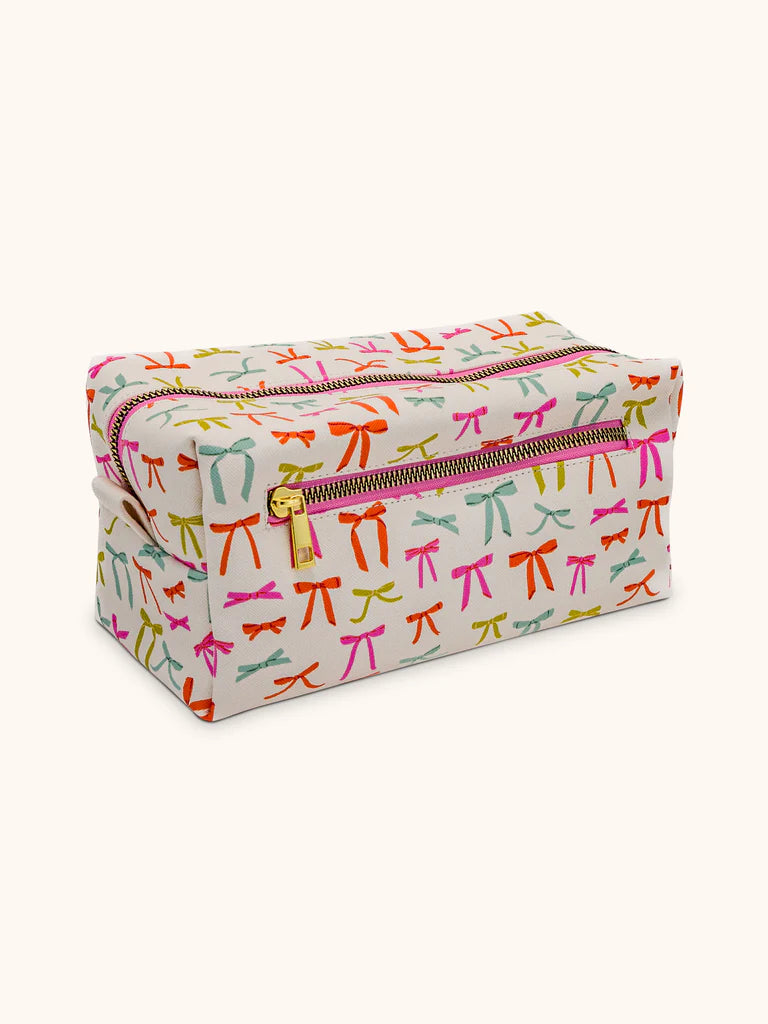 off white sipper bag printed with an all-over pattern of colorful ribbon bows.