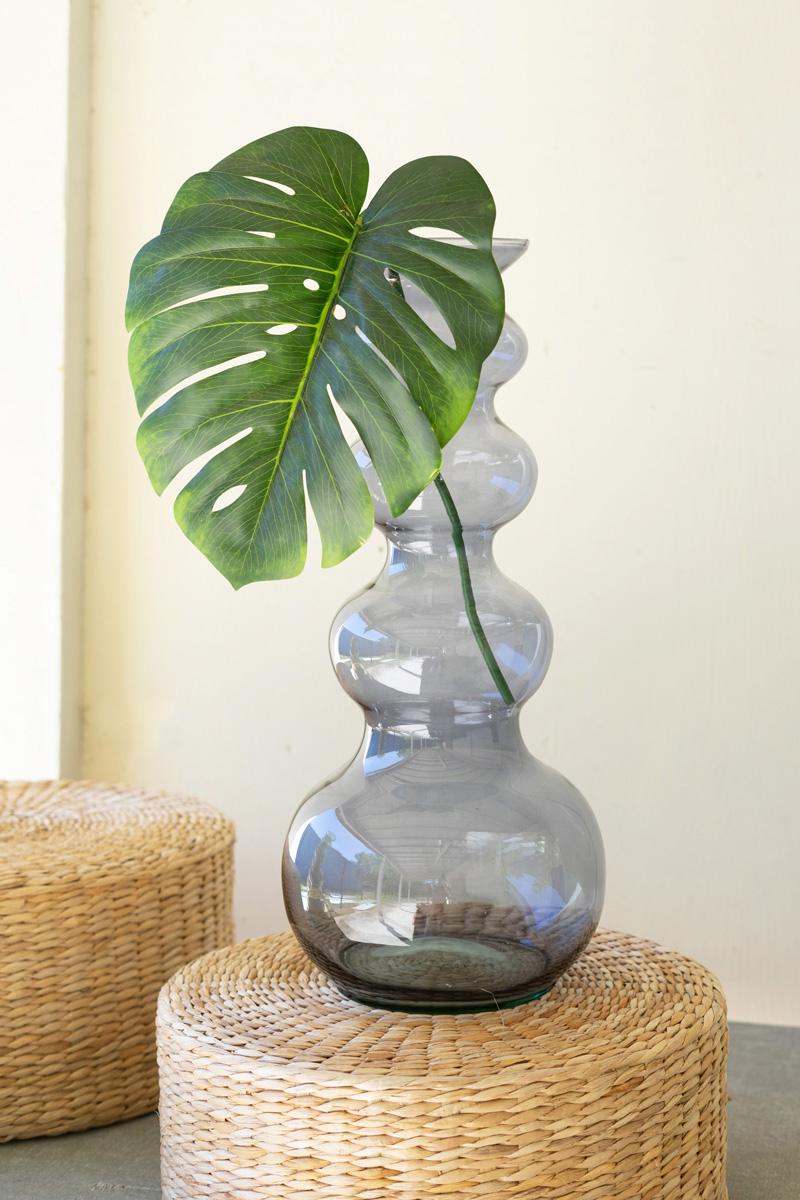blue bubble vase with a green leaf in it