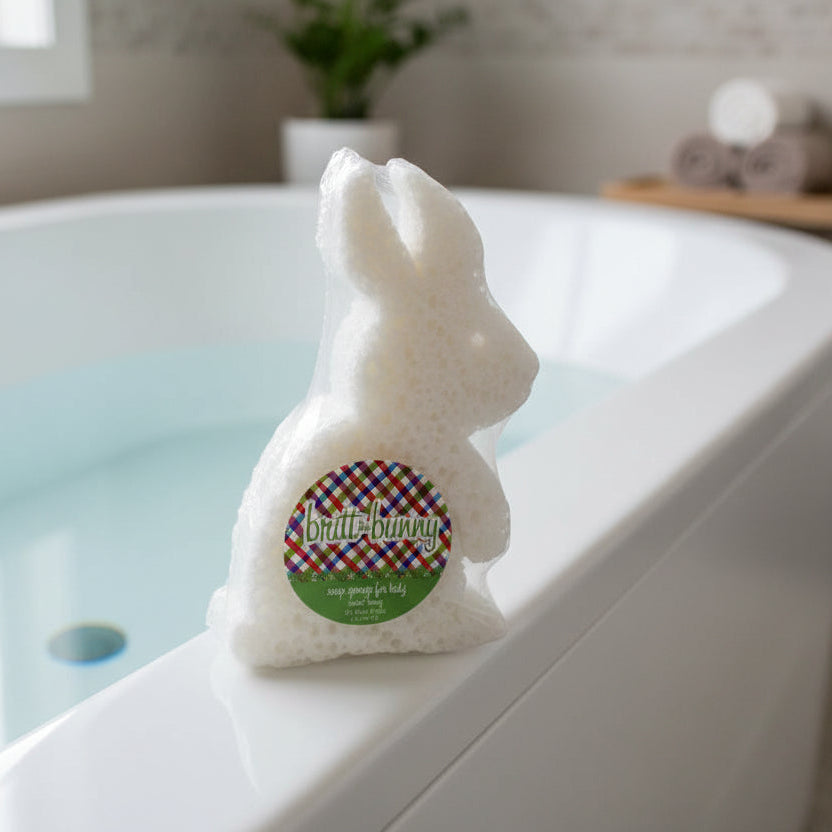 white Bunny-shaped bath sponge set on the rim of a filled bathtub