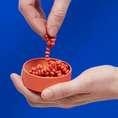 hands playing with coral magnetic pebbles