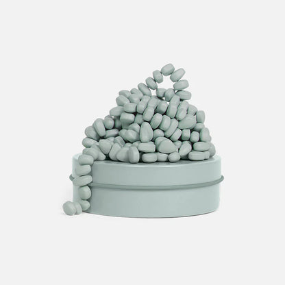 sage colored magnetic pebbles on a tin