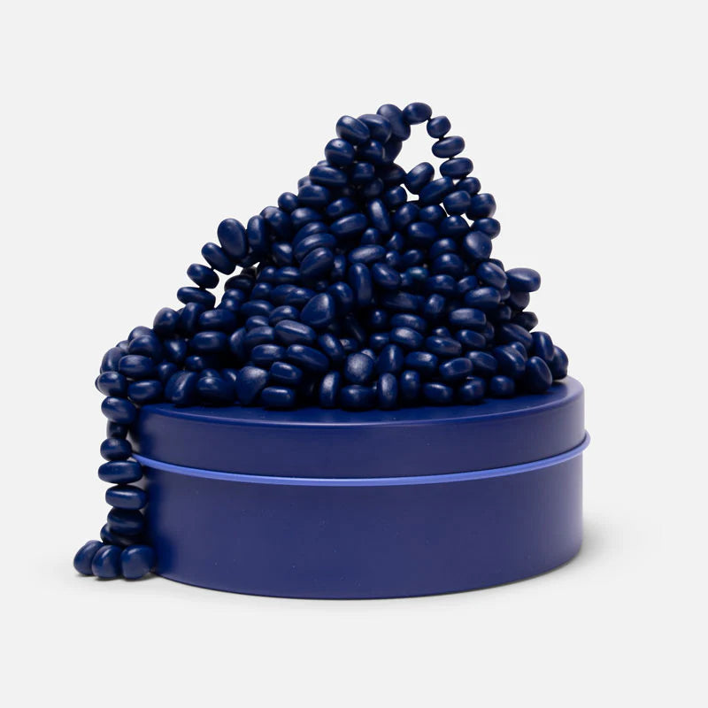 pile of indigo magnetic stone on a matching tin