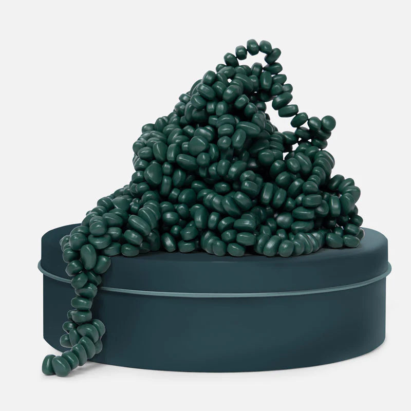 pile of jade colored magnetic stones on a matching tin