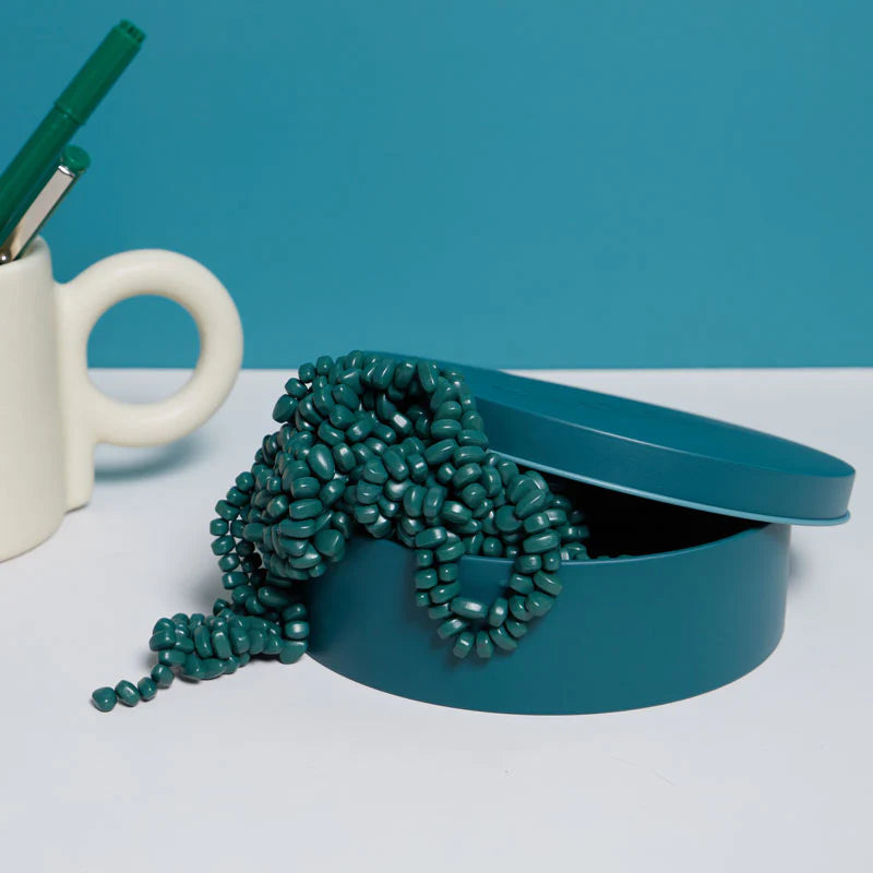 jade crags spilling out of their tin on a desk