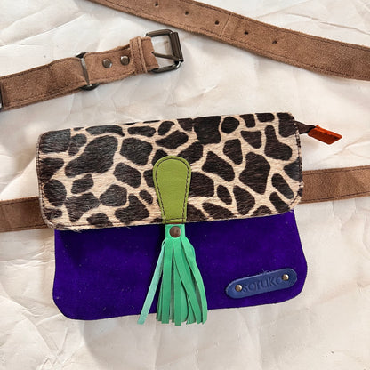 juliette bag with animal print flap, green tassel, and belt arranged with it.