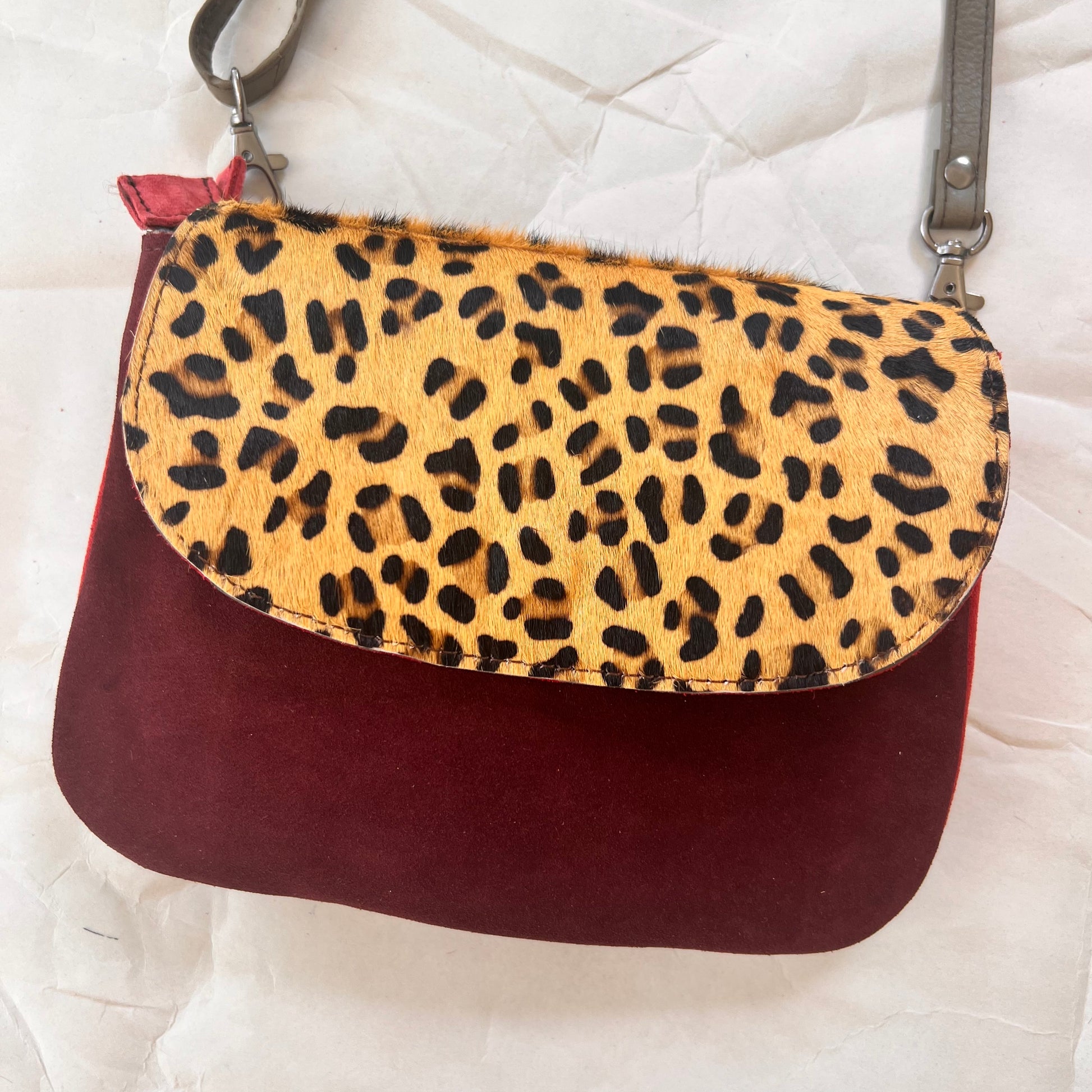 leo purse with a wine body and animal print flap.